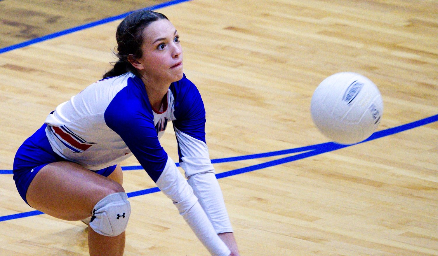 Kallie Hoover eyes the ball as she lunges forward for a dig. [view more volleyball shots]